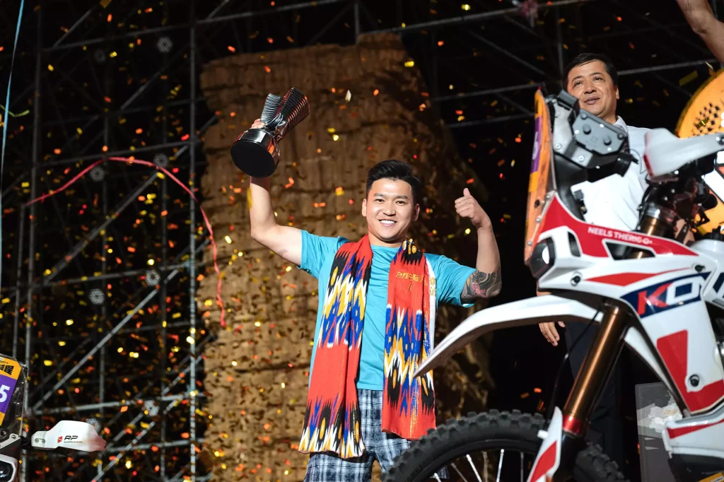 KOVE 450 Rally EX rider lifting championship trophies at 2025 Dahaidao Rally award ceremony
